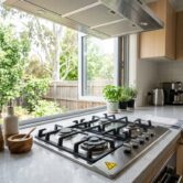 Gas safety plan for Canberra homes showing a kitchen gas cooktop, open window, and caution warning symbol with no people.